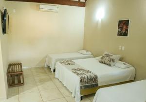 a room with three beds in a room at Hotel Fazenda Haras RD in Olímpia