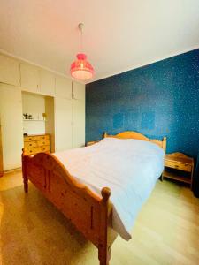 a bedroom with a wooden bed with a blue wall at Alam,s Villa in Kabelvåg