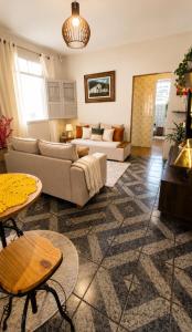 a living room with a couch and a table at Casa Completa No Centro Para Famílias e Grupos Até 9 Hospedes Com Garagem in Ouro Preto