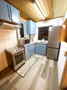 a kitchen with blue cabinets and a stainless steel refrigerator at Ola in Puchuncaví