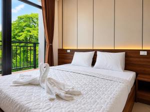 a bedroom with a white bed with a swan on it at Lucky Hostel in Vientiane +33 photos