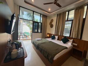 a bedroom with a bed in a room with windows at Moon and Root in Narendranagar