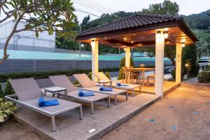 a gazebo with lounge chairs and a table at Katanoi Resort in Kata Beach
