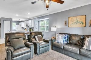 a living room with two leather chairs and a couch at Cozy Lakeside Getaway - Outdoor Theater - Free Early Check-In- 4min to Silver Dollar City in Branson