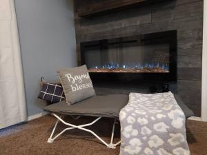 a living room with a chair and a fireplace at Cozy Lakeside Getaway - Outdoor Theater - Free Early Check-In- 4min to Silver Dollar City in Branson +47 photos