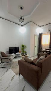 a living room with a couch and two chairs at Les résidences Merryke 1 in Abidjan +2 photos