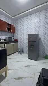 a kitchen with a refrigerator in the middle of a room at Les résidences Merryke 1 in Abidjan
