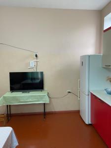 a kitchen with a refrigerator and a table in a room at Holiday home in Qusar
