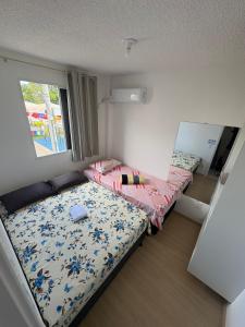 a small bedroom with two beds and a window at Aconchego estrada do coco in Camaçari +63 photos