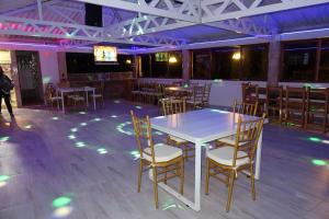 a dining room with a white table and chairs at Finca eventos Dalubsu in Silvania