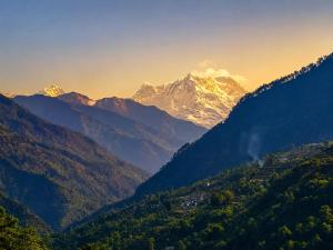 a view of a mountain range with snow capped mountains at Hotel vidya om palace in Ukhimath