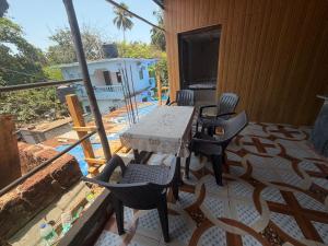 a patio with a table and chairs on a balcony at Swastik Guest House in Arambol