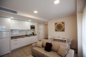 a living room with a couch and a kitchen at Apartamentos Massó in Albacete