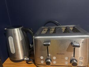 a toaster and a coffee pot on a counter at Private and comfortable guesthouse in Christchurch