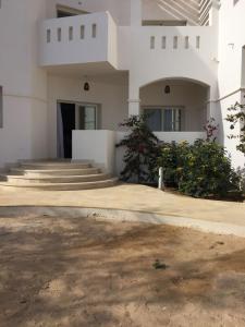 a large white building with stairs and a door at Twin Lagoon Apartment at White Villas El Gouna in Hurghada