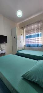 a bedroom with a large green bed with a window at Mali's Apartment in Tirana