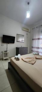 a bedroom with a large bed with a flat screen tv at Mali's Apartment in Tirana