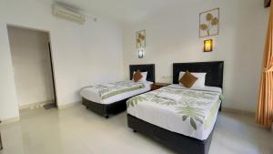 a bedroom with two beds in a room at Waringin Homestay in Kuta