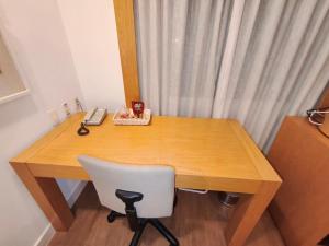 a wooden desk with a chair and a telephone at Flat Aeroporto Congonhas in São Paulo