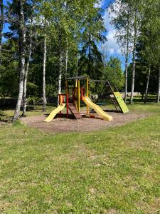 a playground with two slides in a park at Kargevärava kämping in Kapra