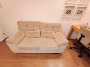 a white couch in a living room with a table at Flat Aeroporto Congonhas in São Paulo