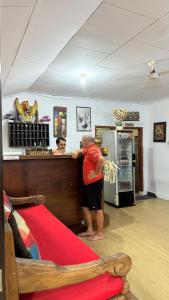 a man standing at a counter in a store at Waringin Homestay in Kuta