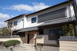 a black and white building with a gate at 竹葉庵 in Nagaokakyo