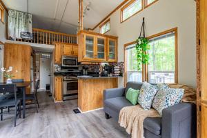 a living room with a couch and a kitchen at The Nook Tiny Home Fire Pit Close to Lake in Maple Lake