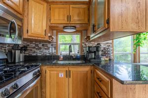 a kitchen with wooden cabinets and a counter top at The Nook Tiny Home Fire Pit Close to Lake in Maple Lake
