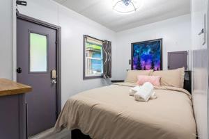 a bedroom with a large bed with pink and white pillows at The Cranny Tiny Home Fire Pit Close to Lake in Maple Lake