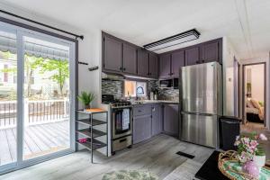a kitchen with purple cabinets and a stainless steel refrigerator at The Cranny Tiny Home Fire Pit Close to Lake in Maple Lake