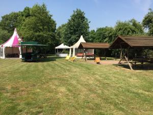 a group of tents and picnic tables in a field at Hotel Schützenhaus in Brück