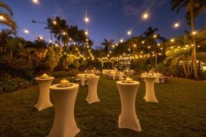a group of tables with lights in a garden at night at Picnic Bay Hotel in Picnic Bay
