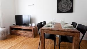jadalnia ze stołem, krzesłami i telewizorem w obiekcie Italianway-Scarlatti w Mediolanie