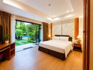 a bedroom with a bed and a sliding glass door at Nova Park Hotel Pattaya in Pattaya
