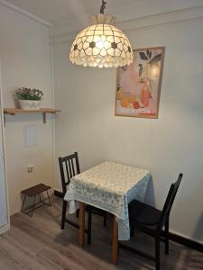 a dining room with a table and chairs and a chandelier at Üdülő in Gárdony