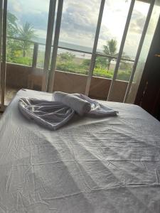 a bed with a towel on it in front of a window at Villa Encanto in Bahía Solano +6 photos