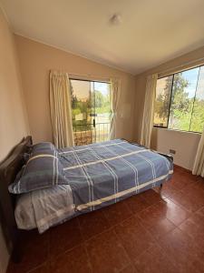 a bedroom with a bed in a room with windows at Casa los Cipreses del Sol in Cieneguilla +30 photos