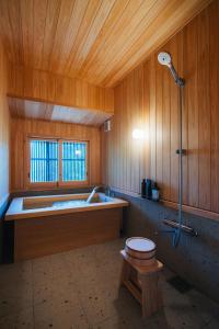 ein großes Badezimmer mit Badewanne und Dusche in der Unterkunft Hotel Raccan in Shibushi