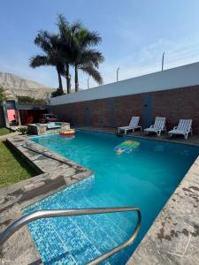 a swimming pool with two lounge chairs in a resort at Casa los Cipreses del Sol in Cieneguilla