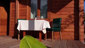 a table and two green chairs on a porch at Sakin Vadi Winehouse in Orhaniye