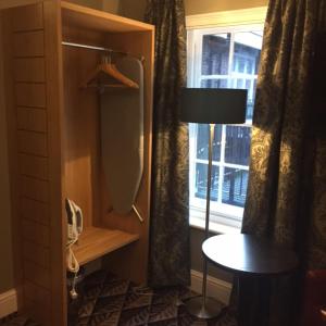a room with a table and a lamp and a window at The Bell Hotel Aylesbury in Aylesbury
