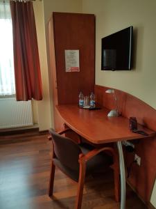 a room with a desk with a chair and a television at Hotel Restauracja Kinga in Katowice