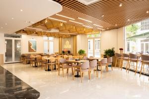 a restaurant with tables and chairs in a lobby at Devesun Boutique Hotel Phú Quốc in Phú Quốc