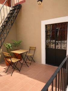a patio with a table and chairs and a door at Hotel Meson Cuevano in Guanajuato
