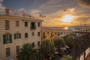 a sunset over a city with buildings and palm trees at Devesun Boutique Hotel Phú Quốc in Phú Quốc