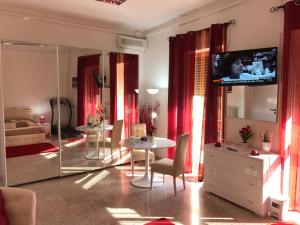 ein Wohnzimmer mit einem TV, einem Tisch und Stühlen in der Unterkunft B&B del Benessere Beauty & Welness in Maglie