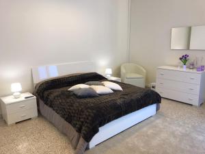 ein Schlafzimmer mit einem Bett mit Kissen und zwei Nachttischen in der Unterkunft B&B del Benessere Beauty & Welness in Maglie