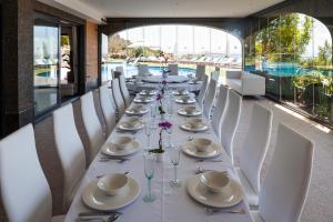 a long table with white chairs and plates and glasses at Fuente de Ibiza in Sant Jordi
