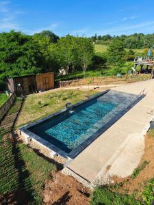 a swimming pool in the middle of a yard at Gîte Chez EVA in Le Buisson de Cadouin